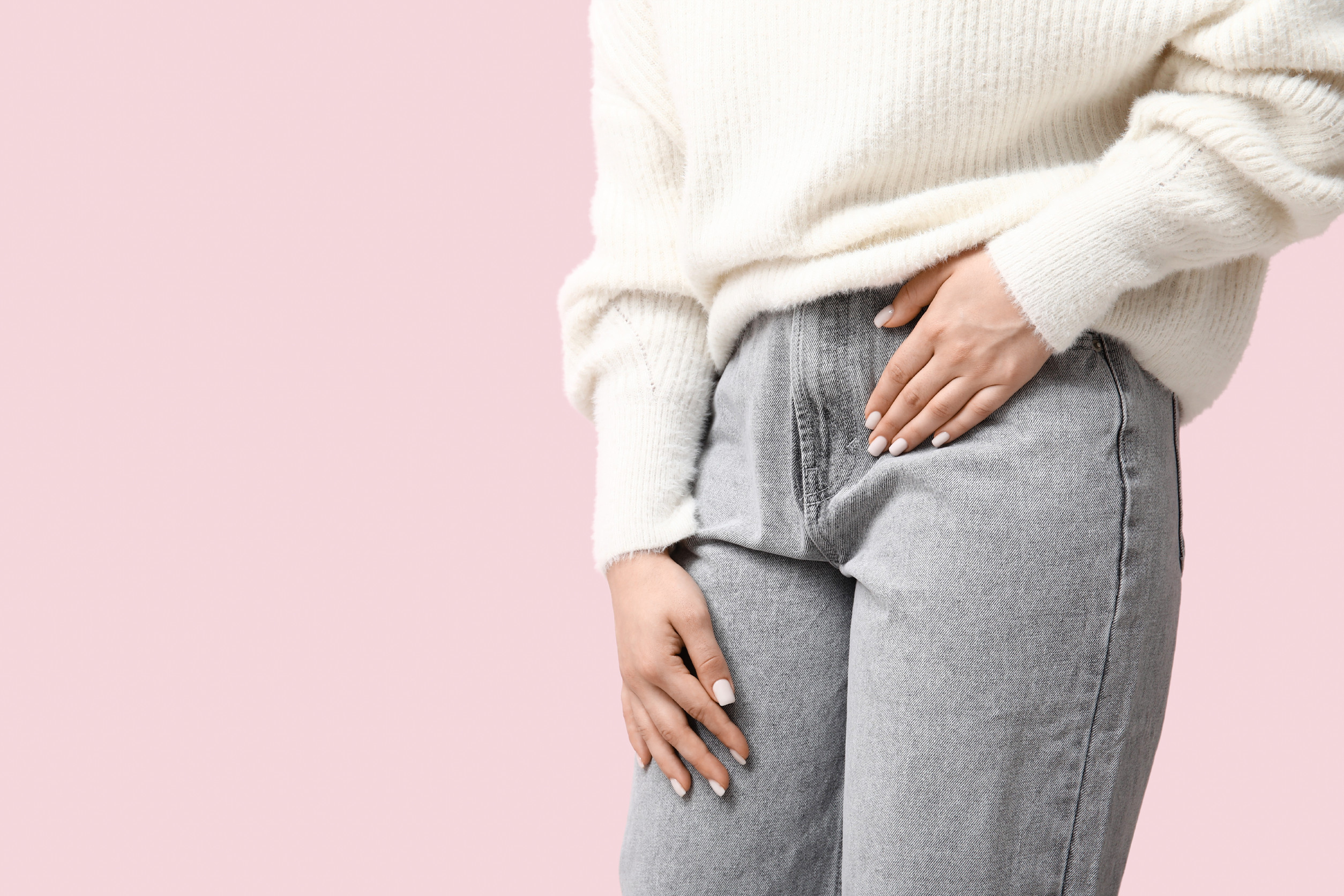 Young woman suffering from cystitis on pink background, closeup Young woman suffering from cystitis on pink background, closeup<br />